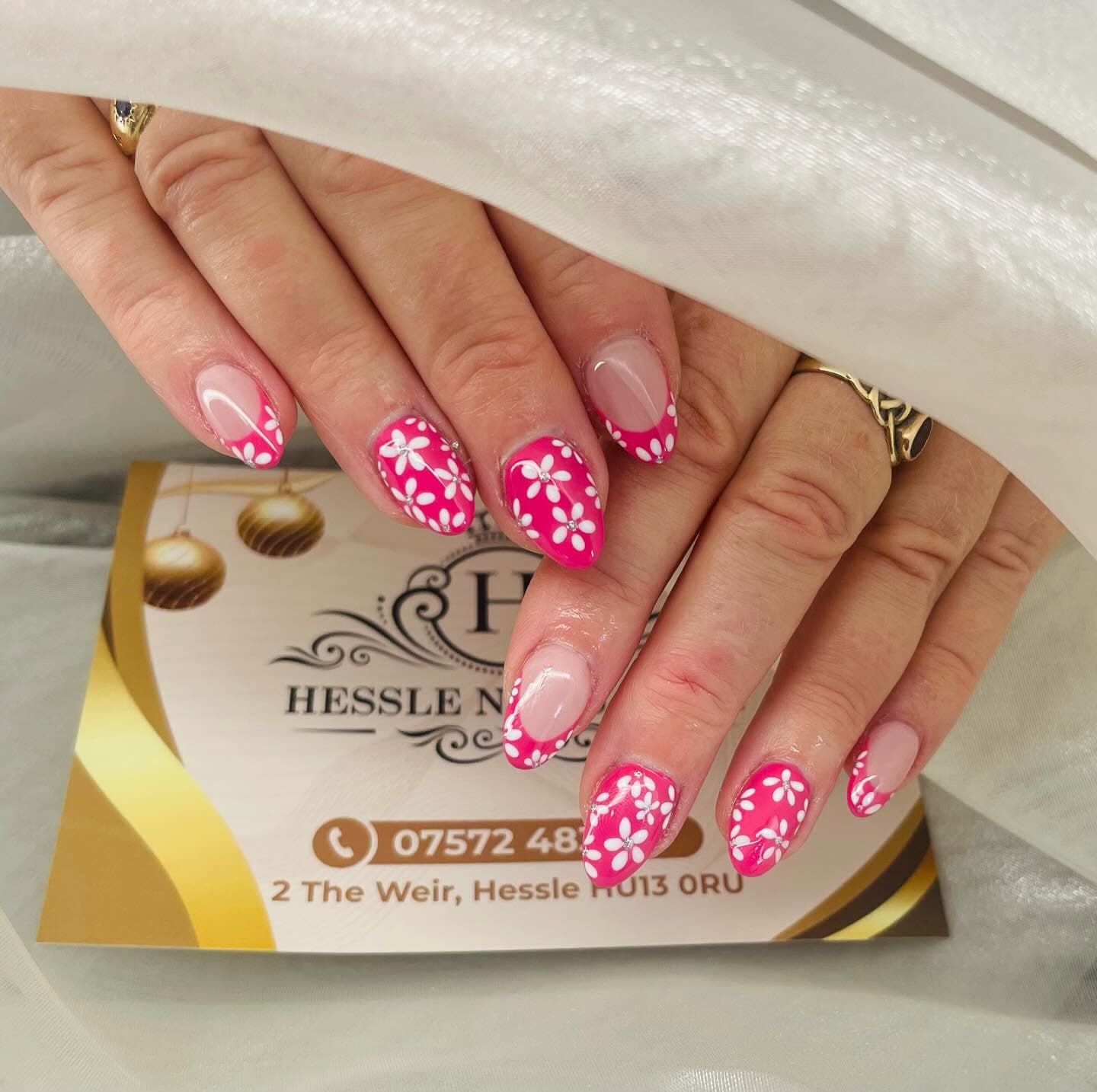 Hot pink nails with hand-painted white daisies